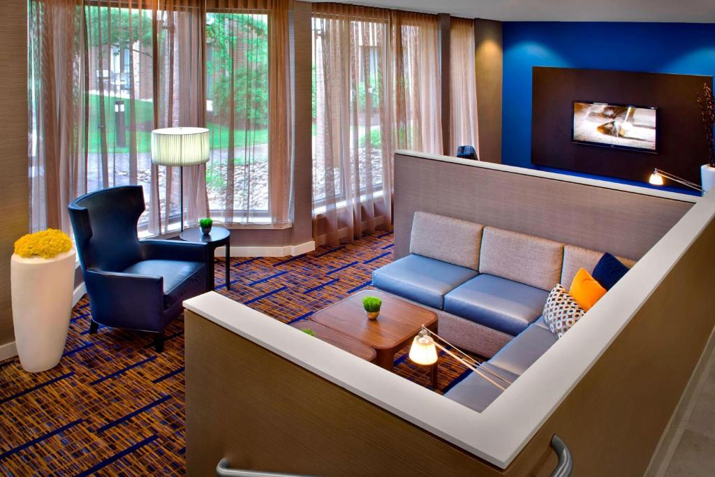 a living room with a couch and a chair at Courtyard By Marriott Hartford Windsor Airport in Windsor