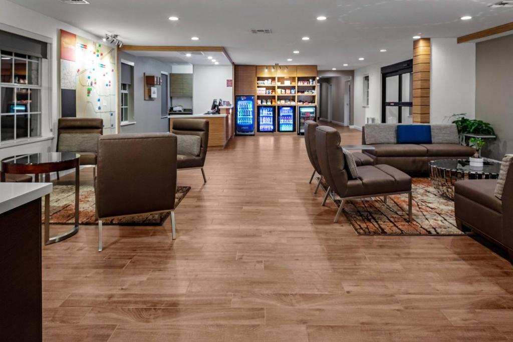 un vestíbulo de un hospital con sillas y mesas en TownePlace Suites by Marriott Dallas Plano/Legacy, en Plano