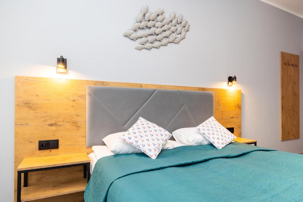 ein Schlafzimmer mit einem blauen Bett mit Kissen darauf in der Unterkunft Villa Livia in Niechorze