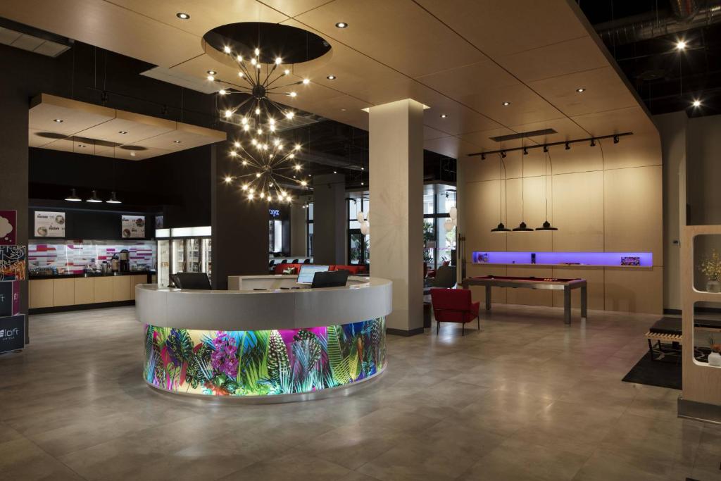 a lobby with a waiting area with a table in it at Aloft Coral Gables in Miami