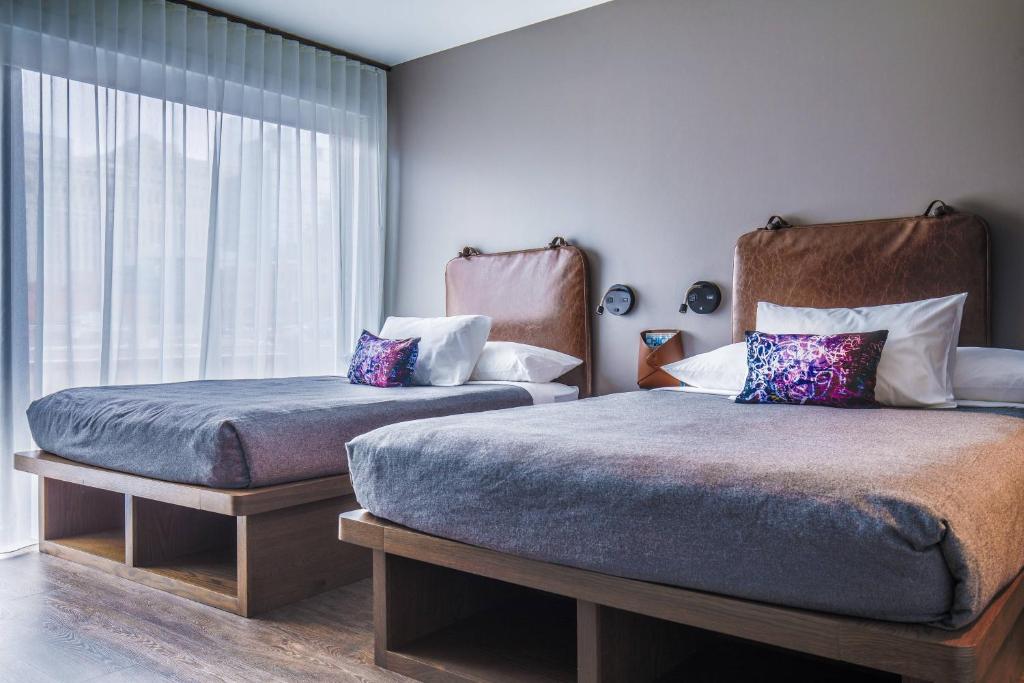Un dormitorio con dos camas y una ventana. en Moxy Chicago Downtown, en Chicago