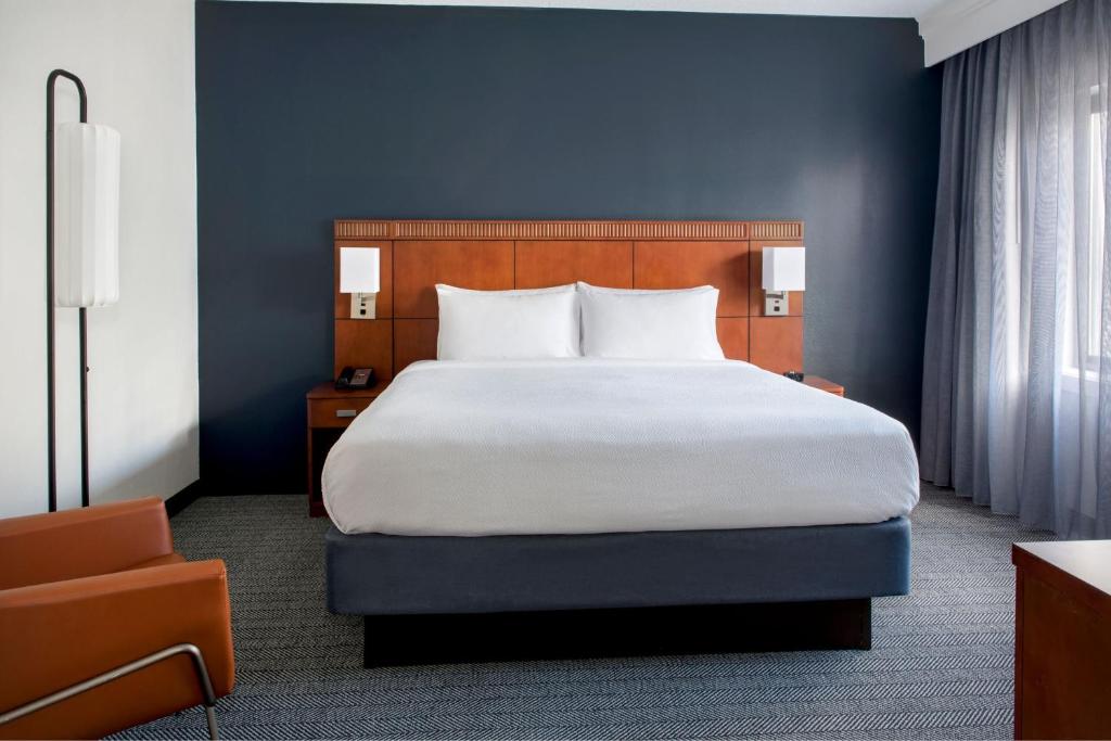 Courtyard by Marriott Annapolis في أنابوليس: غرفة نوم بسرير كبير وجدار ازرق