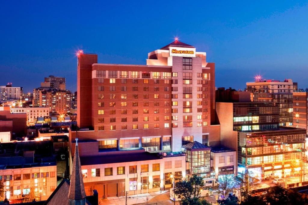 a view of a building in a city at night at Sheraton LaGuardia East Hotel in Queens