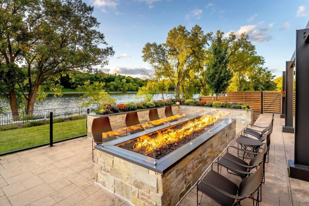 a patio with a fire pit with chairs around it at Courtyard by Marriott Appleton Riverfront in Appleton