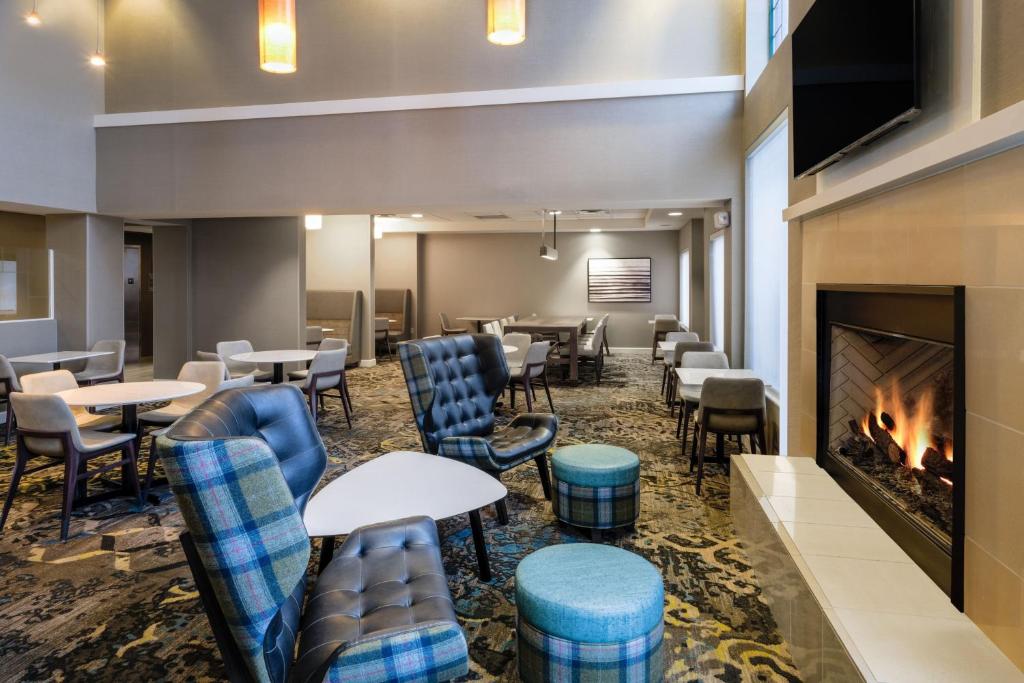 ein Restaurant mit Tischen und einem Kamin in der Unterkunft Residence Inn by Marriott Chicago Oak Brook in Oak Brook