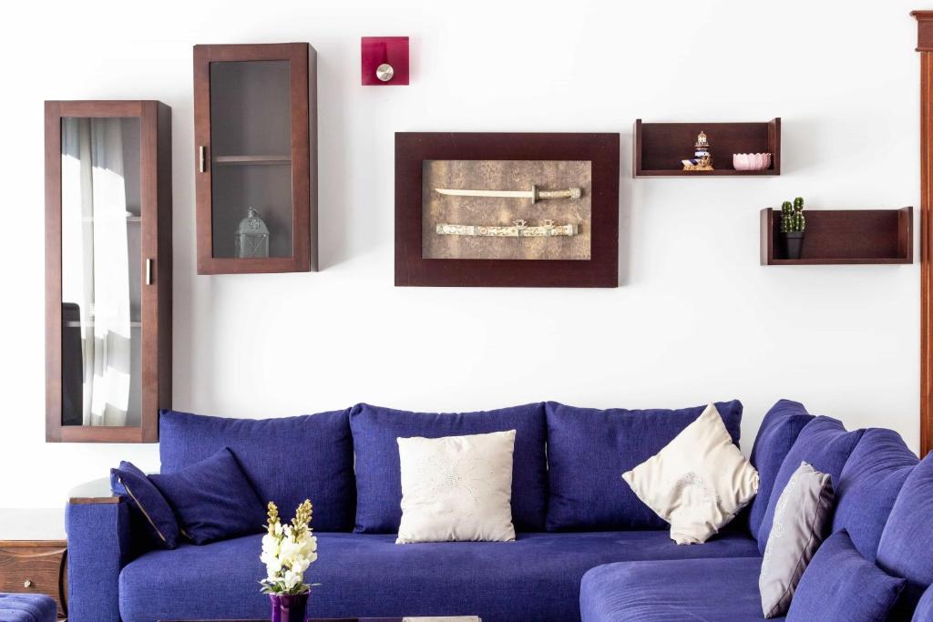 a blue couch in a living room with mirrors at Appartement Haut Standing Central Corniche in Tangier