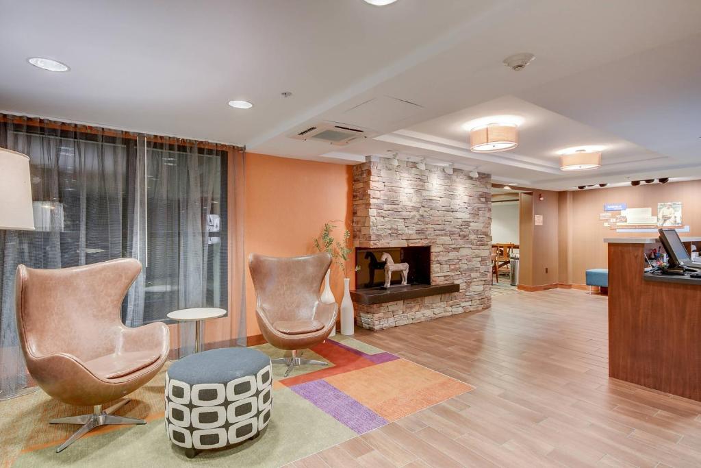 a lobby with two chairs and a fireplace at Fairfield Inn Boston Woburn in Woburn