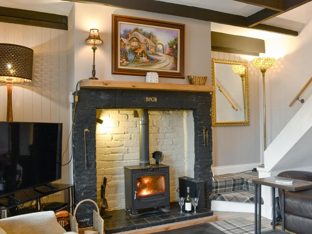 a living room with a brick fireplace with a fire place at The Nook in Bardon Mill