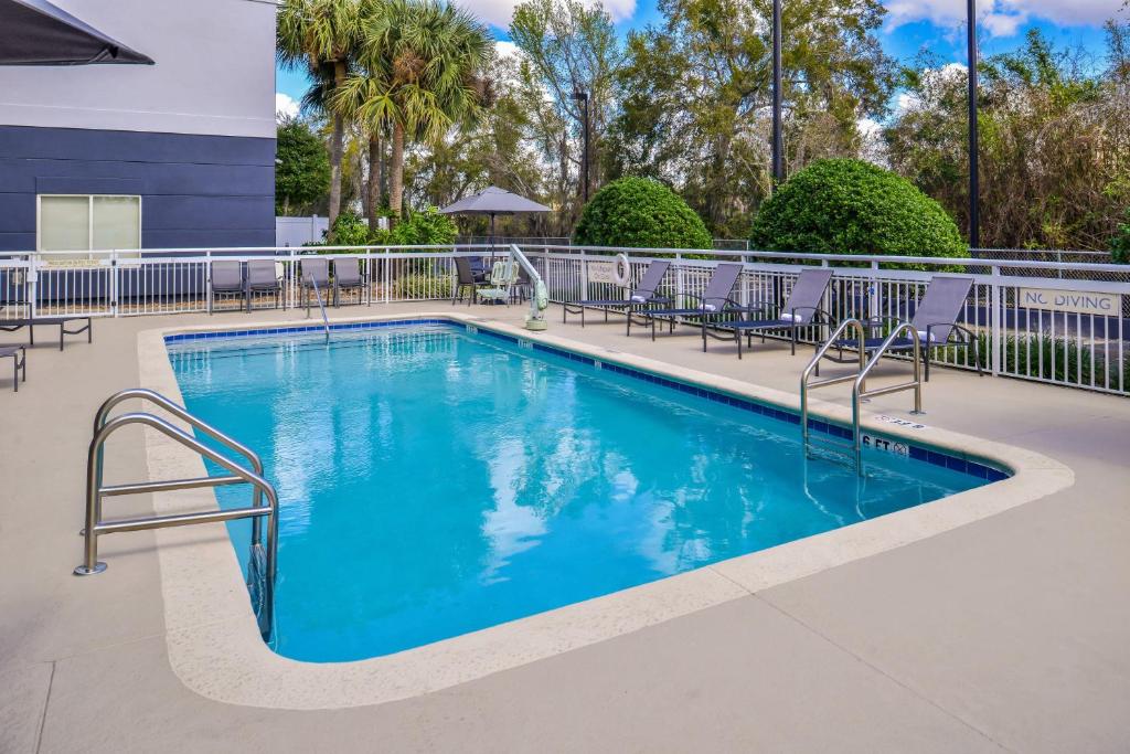 a swimming pool at a resort with tables and chairs at Fairfield Inn & Suites by Marriott Ocala in Ocala