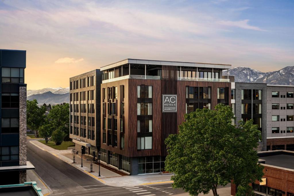 an rendering of an apartment building with mountains in the background at AC Hotel by Marriott Bozeman Downtown in Bozeman