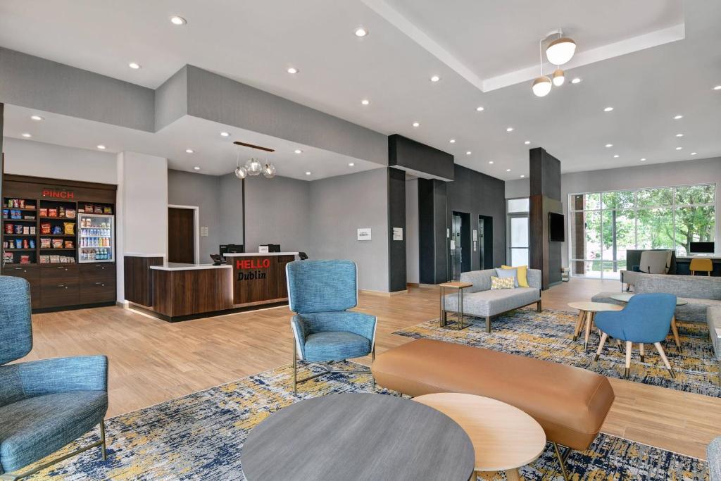 eine Lobby einer Bibliothek mit blauen Stühlen und Tischen in der Unterkunft TownePlace Suites by Marriott Columbus Dublin in Dublin