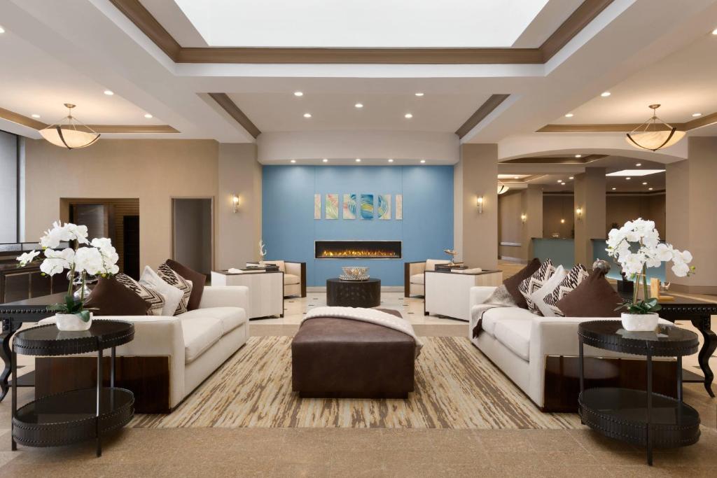 uma sala de estar com sofás e uma lareira em Delta Hotels by Marriott Detroit Metro Airport em Romulus