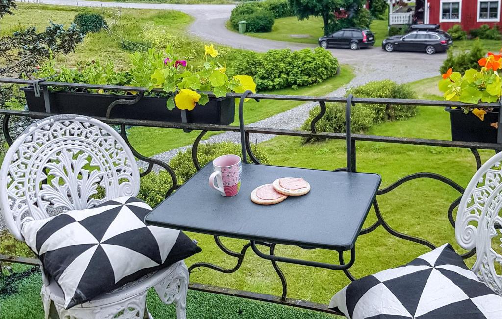 een tafel met twee borden en een kopje op een balkon bij Beautiful Home In Koppom With Wifi And 3 Bedrooms in Koppom