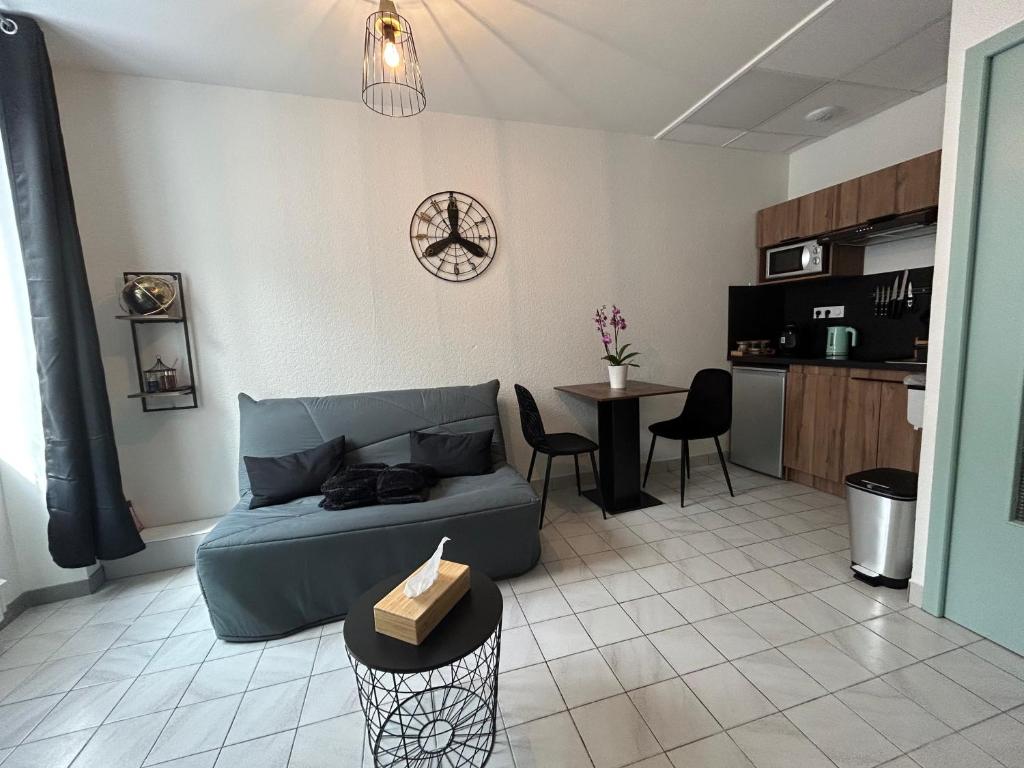 een woonkamer met een bank en een tafel bij Au 15 - Charmant Studio hyper centre in Saint-Amand-Montrond