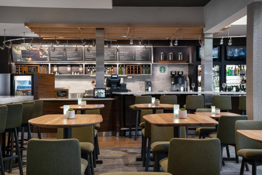 un restaurant avec des tables et des chaises en bois ainsi qu'un bar dans l'établissement Courtyard by Marriott Las Vegas Convention Center, à Las Vegas