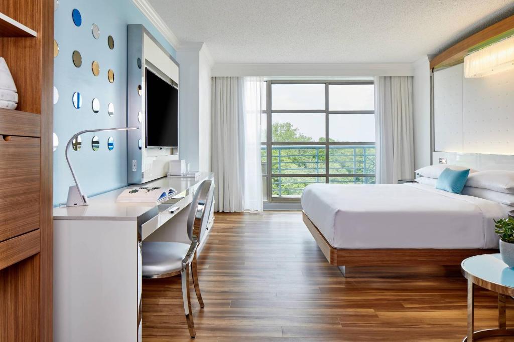 a hotel room with a bed and a desk and a sink at Renaissance Charlotte SouthPark Hotel in Charlotte