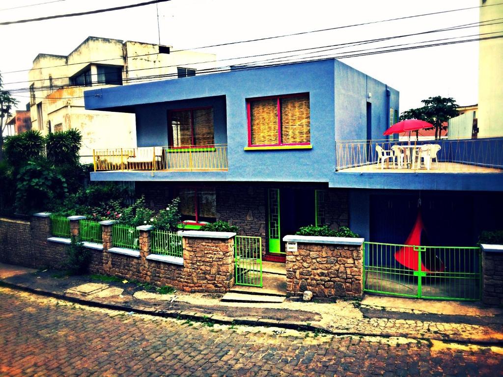ein blaues Haus mit einem Tisch auf dem Balkon in der Unterkunft Madagascar Underground in Antananarivo