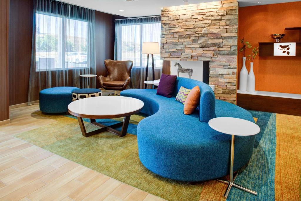 a living room with a blue couch and a fireplace at Fairfield Inn & Suites by Marriott Hollister in Hollister