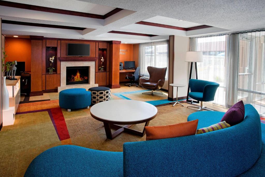 a living room with blue furniture and a fireplace at Fairfield Inn & Suites Merrillville in Merrillville