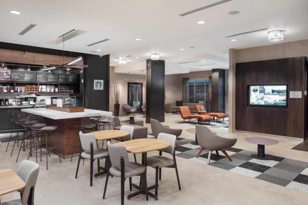 a lobby with tables and chairs and a bar at Courtyard by Marriott Baton Rouge Downtown in Baton Rouge