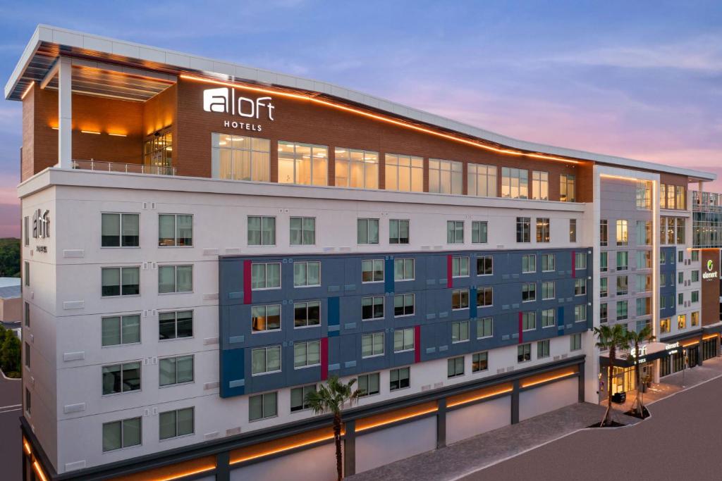 an apartment building with a lit up sign on it at Aloft Tampa Midtown in Tampa