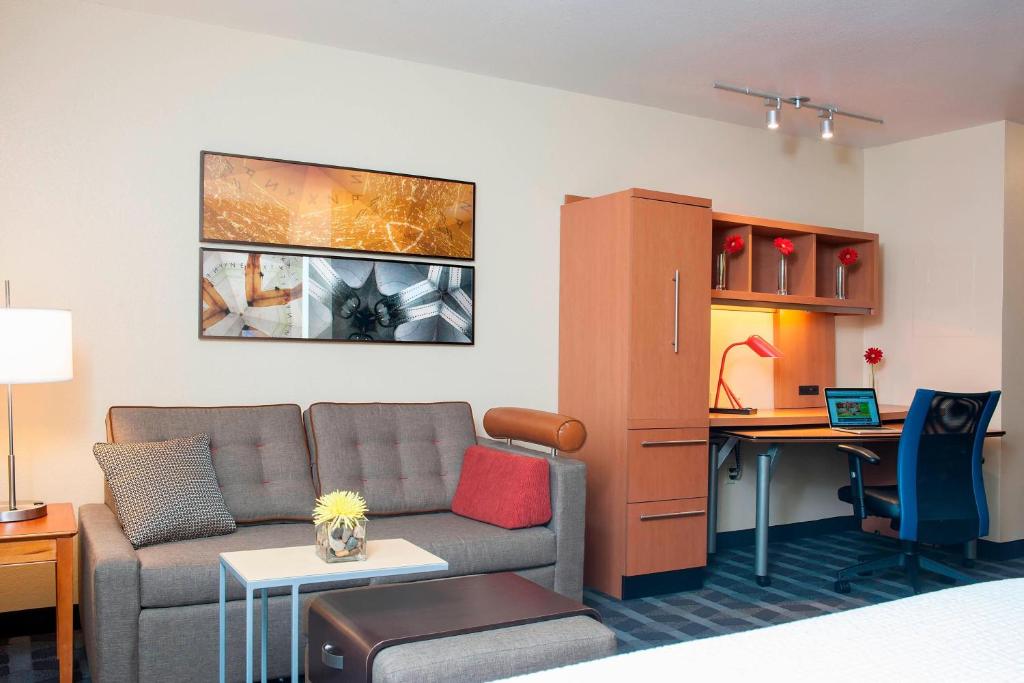 uma sala de estar com um sofá e uma secretária em TownePlace Suites Indianapolis Park 100 em Indianápolis