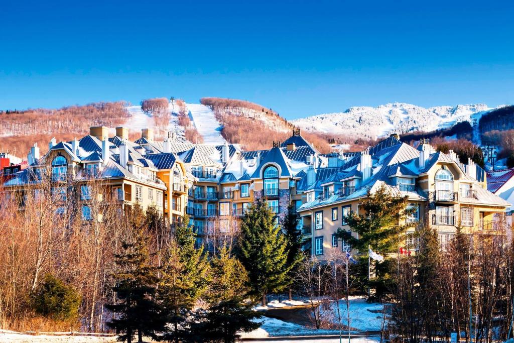 a large apartment building in the mountains with snow at Le Westin Tremblant in Mont-Tremblant