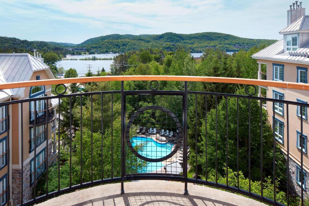 a balcony with a view of a river and buildings at Le Westin Tremblant in Mont-Tremblant