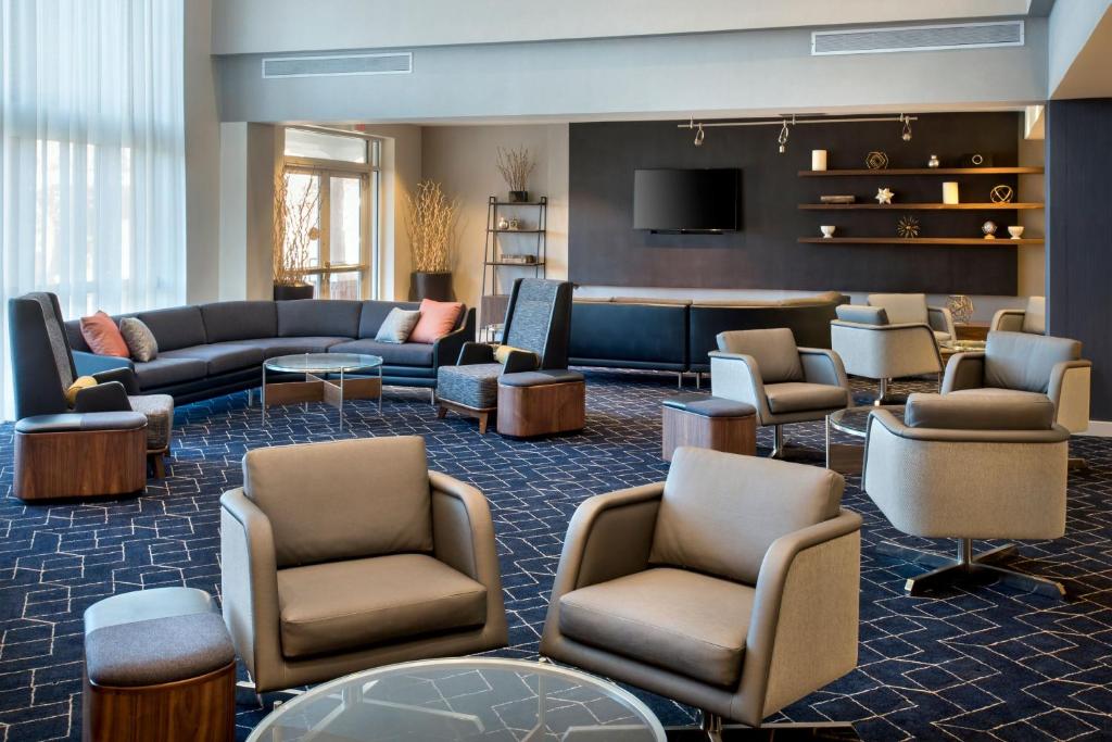 een lobby met banken en stoelen en een televisie bij Courtyard by Marriott Basking Ridge in Basking Ridge