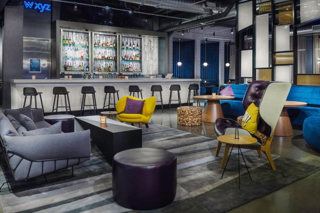 a lobby with colorful chairs and a bar at Aloft Gainesville University Area in Gainesville