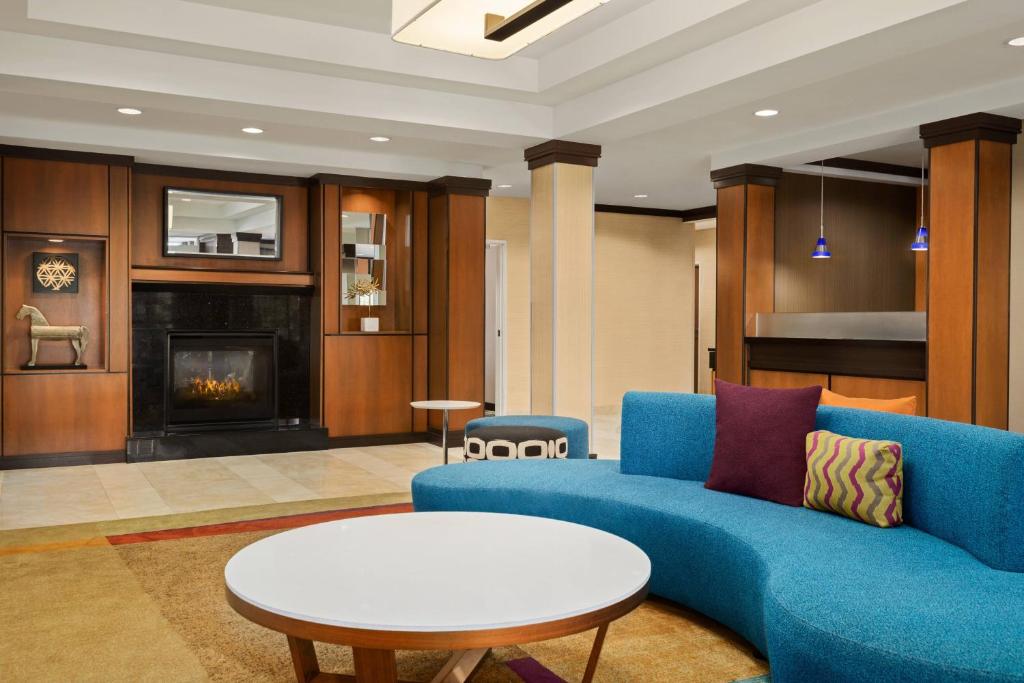 a living room with a blue couch and a fireplace at Fairfield Inn & Suites by Marriott Weirton in Weirton