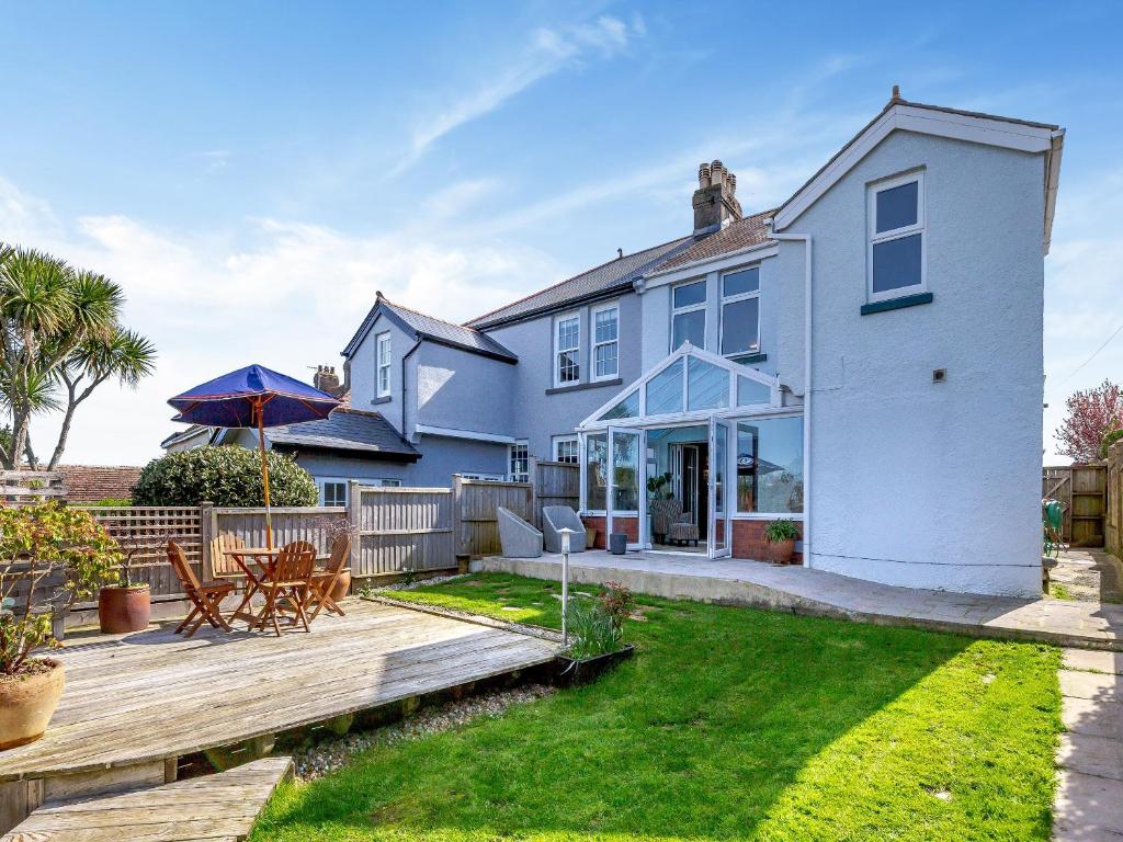 a white house with a deck and a patio at Number 10 in Dartmouth