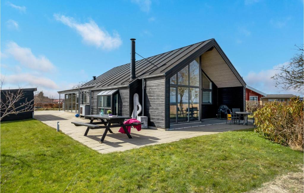 a house with a picnic table in the yard at Awesome Home In Frederikshavn in Frederikshavn