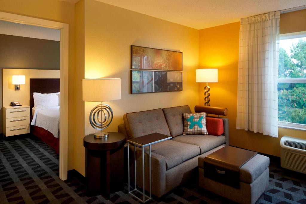 Habitación de hotel con sofá y cama en TownePlace Suites by Marriott Jacksonville, en Jacksonville