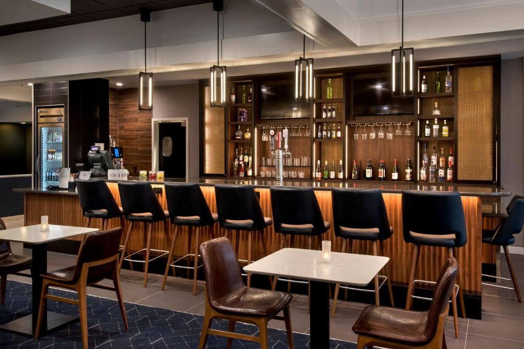 bar ze stołami i krzesłami w restauracji w obiekcie Courtyard by Marriott New Carrollton Landover w mieście Landover