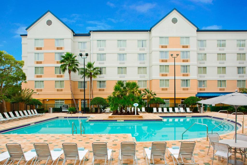 un hotel con piscina, sillas y un edificio en Fairfield Inn & Suites by Marriott Orlando Lake Buena Vista in the Marriott Village, en Orlando