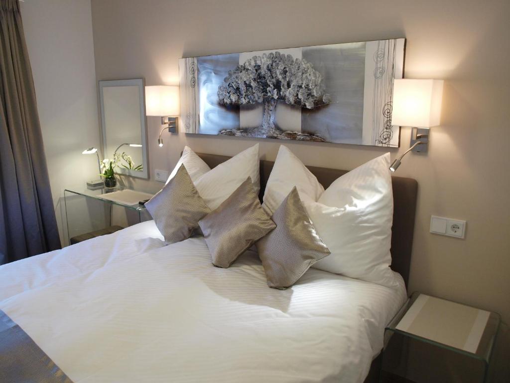 a bedroom with a white bed with four pillows at Lake View Apartment in St. Wolfgang