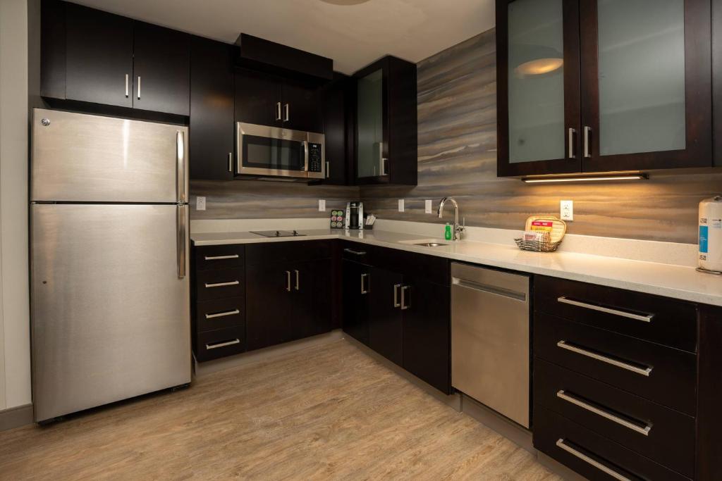 a kitchen with black cabinets and a stainless steel refrigerator at Residence Inn Nashville Mt. Juliet in Mount Juliet