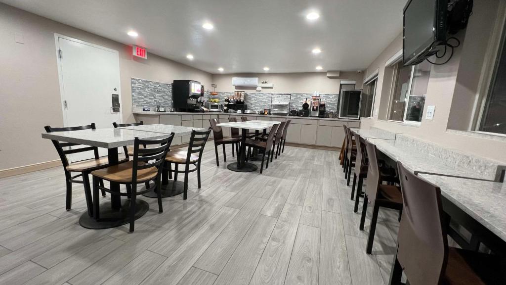 a restaurant with tables and chairs and a kitchen at Best Western El Rancho Palacio in Roswell