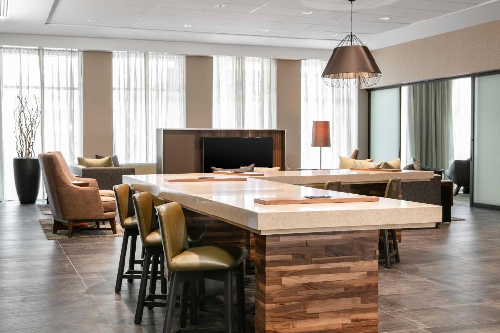 a lobby with a large island in a room with chairs at Courtyard Sioux City Downtown/Convention Center in Sioux City