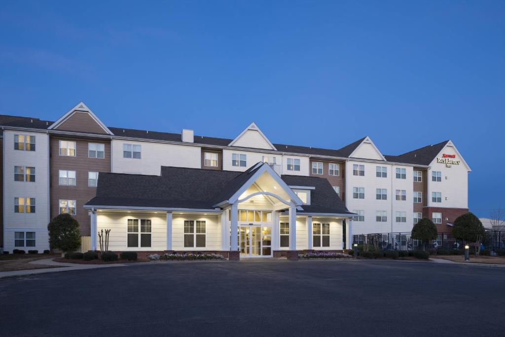 a large white building with a parking lot in front of it at Residence Inn Jackson Ridgeland in Ridgeland