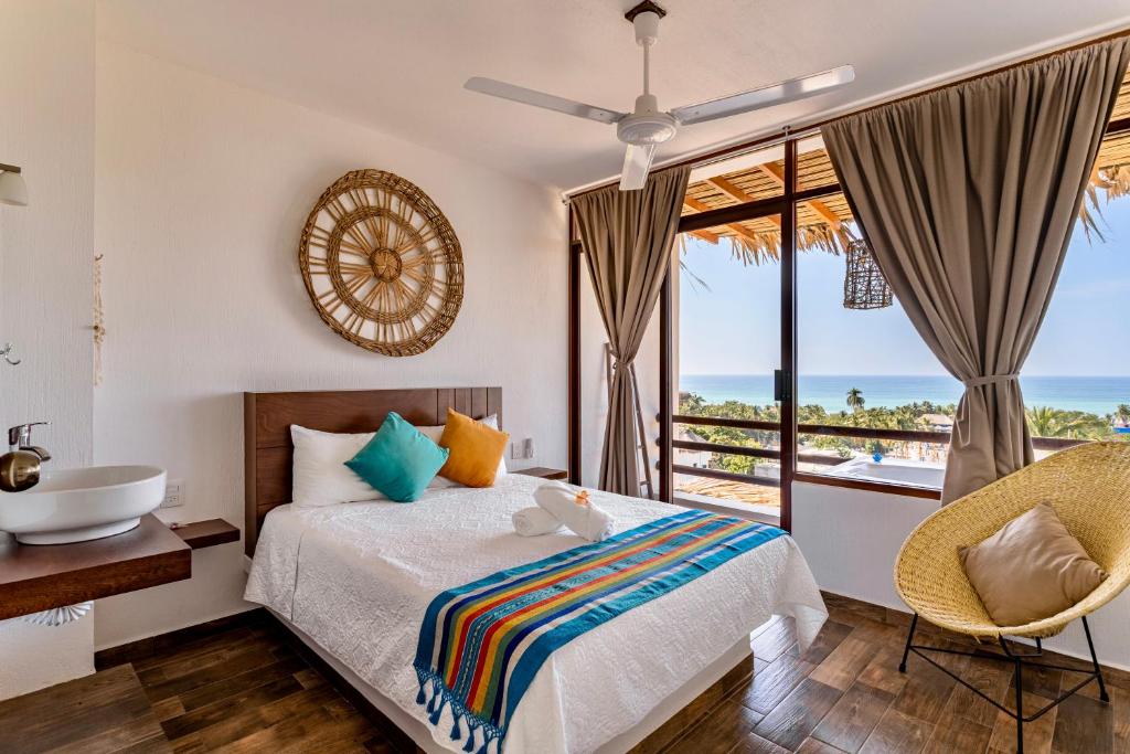 a bedroom with a bed and a view of the ocean at Punta Kai Hotel & Hostal in Puerto Escondido