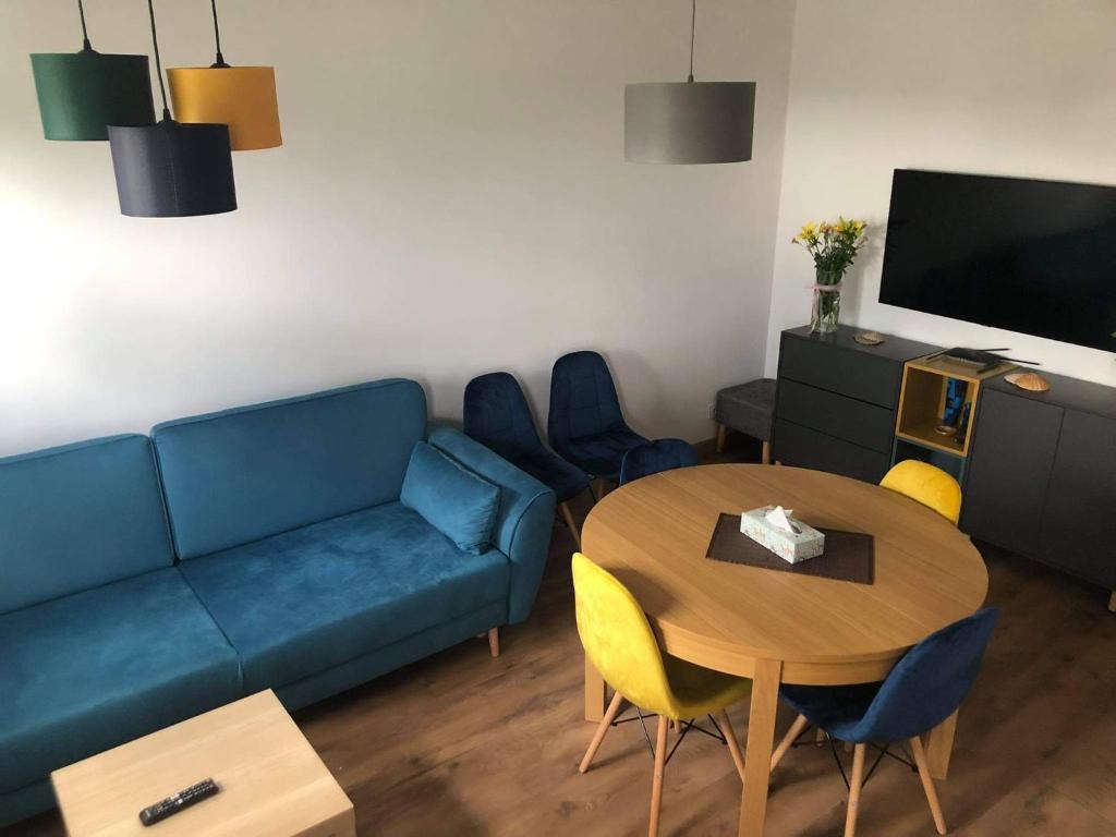 a living room with a blue couch and a table at Apartament u Lali in Ustka
