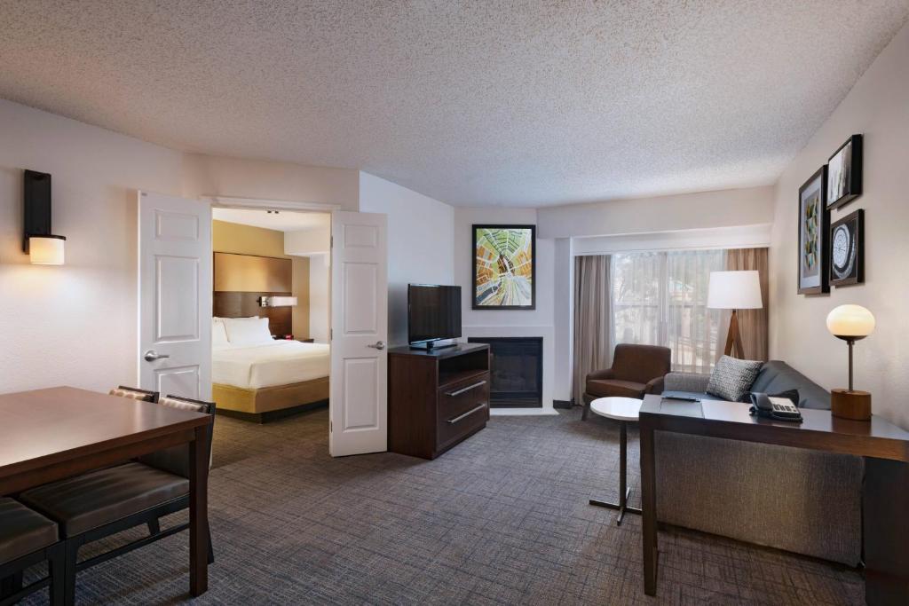 オースティンにあるResidence Inn by Marriott Austin The Domain Areaのベッドとリビングルームが備わるホテルルームです。