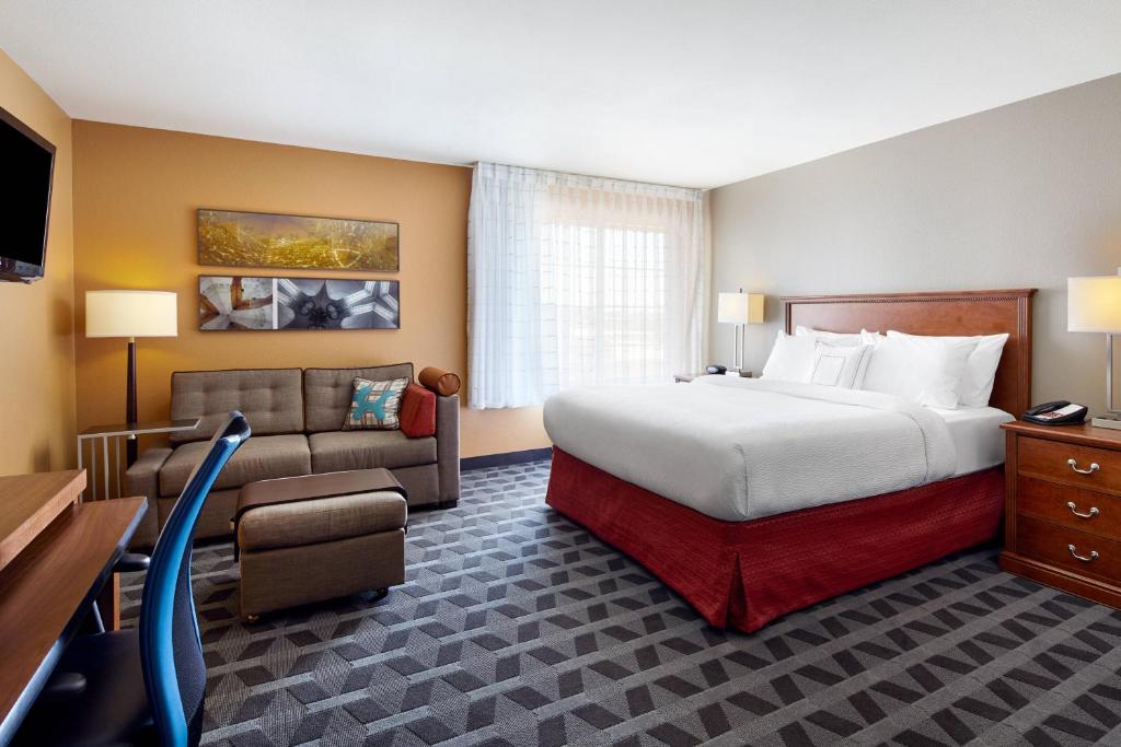 a hotel room with a bed and a couch at TownePlace Suites by Marriott Midland in Midland