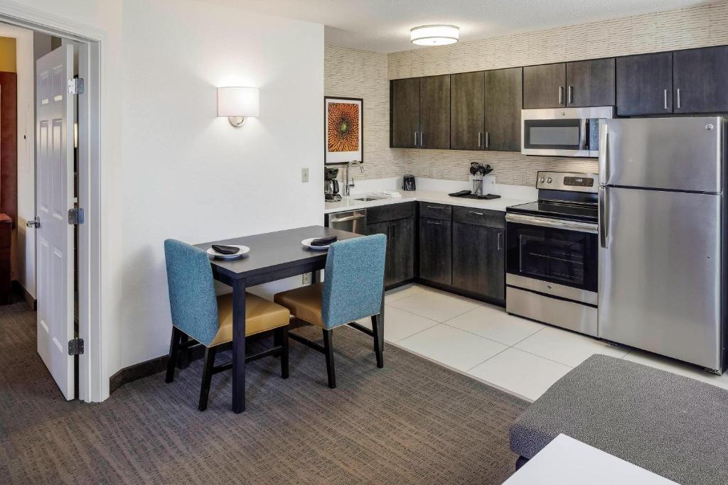 a kitchen with a table and chairs and appliances at Residence Inn by Marriott Portsmouth in Portsmouth