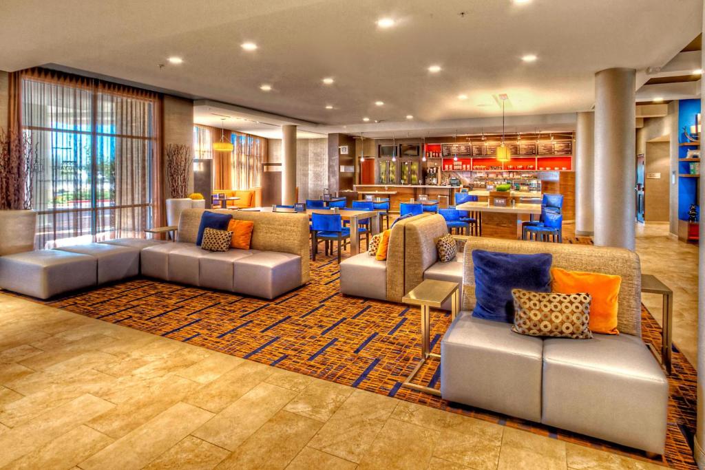 a lobby of a hotel with couches and tables at Courtyard by Marriott San Marcos in San Marcos