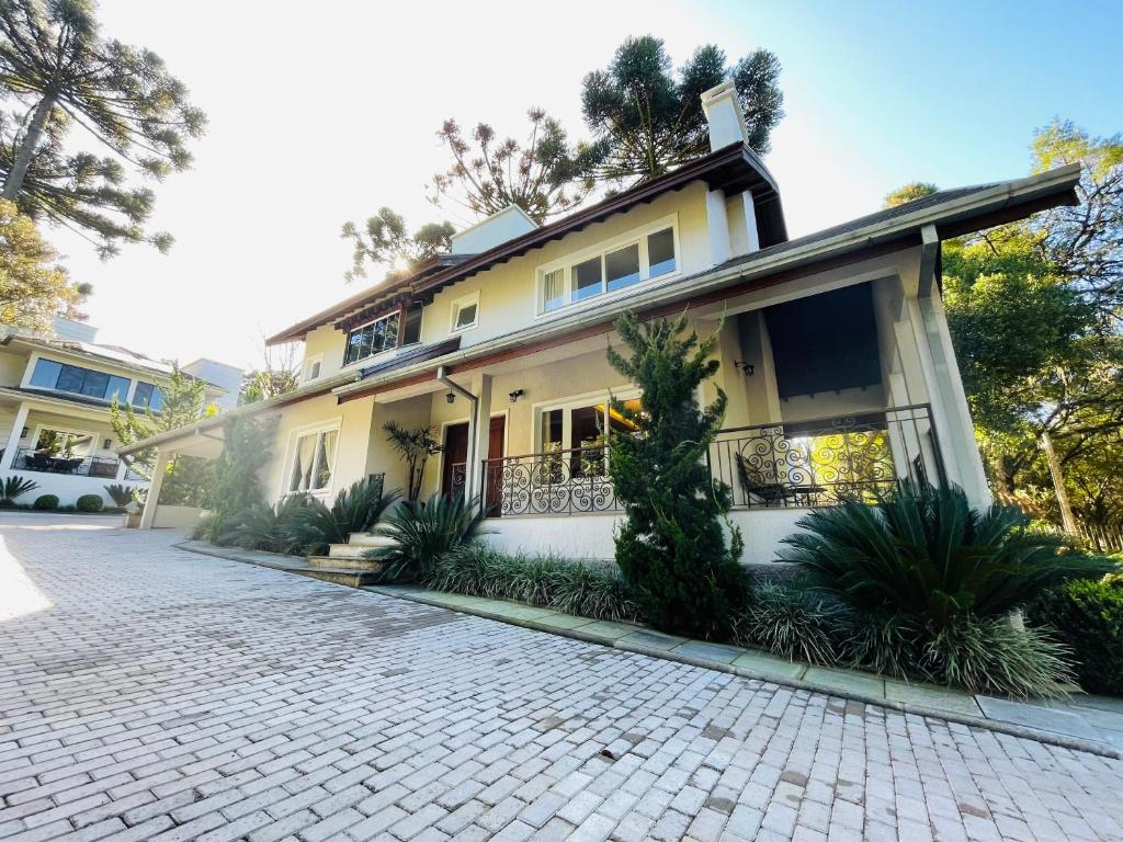 uma casa com uma entrada de tijolos em frente em Residencial Jardim dos Pinheiros 279 em Canela