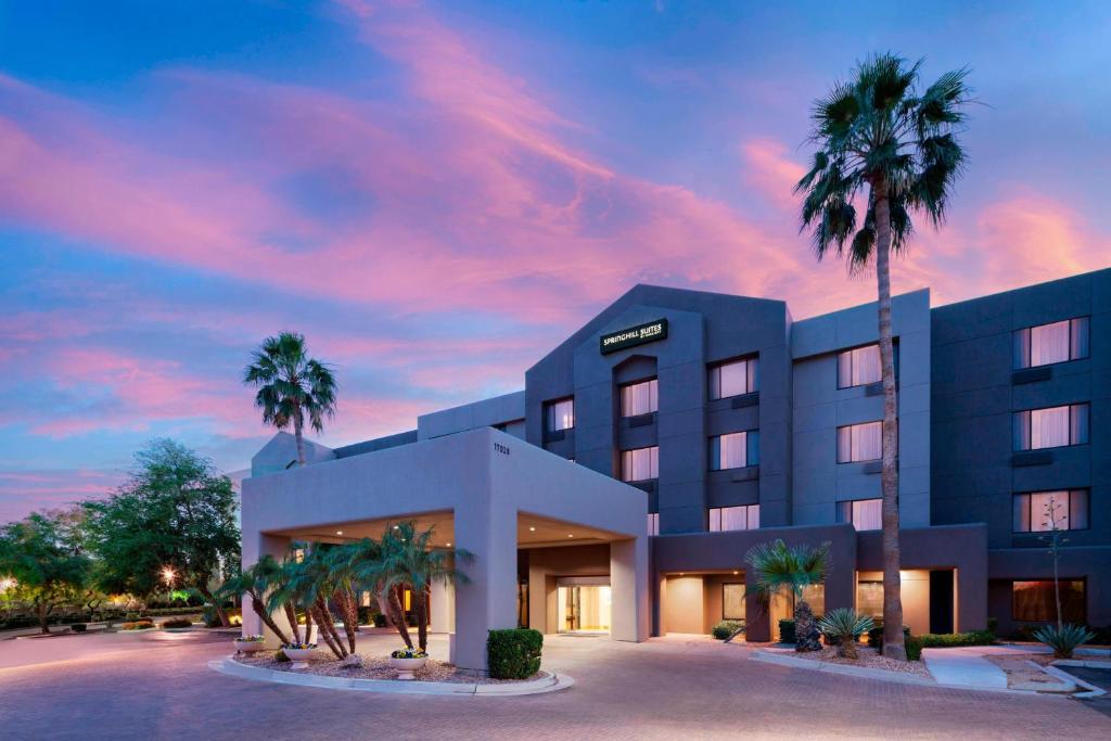 a hotel with palm trees in front of a building at SpringHill Suites Scottsdale North in Scottsdale