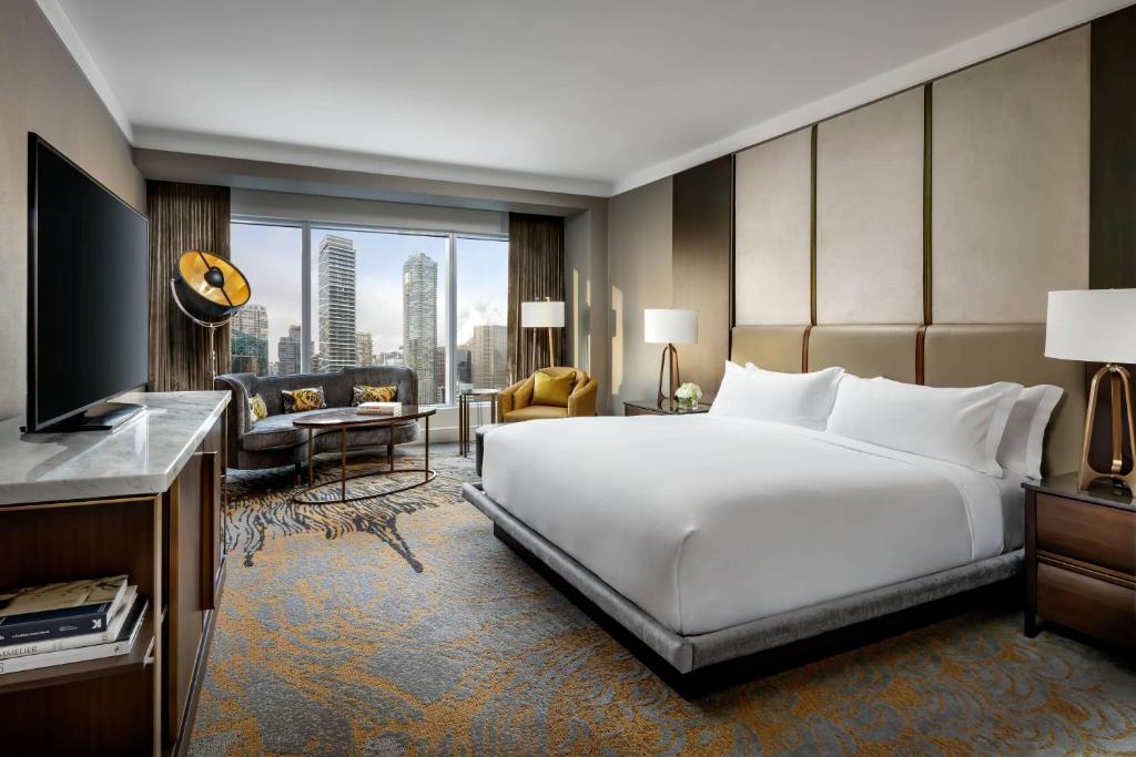 a hotel room with a large bed and a large window at The Ritz-Carlton, Toronto in Toronto